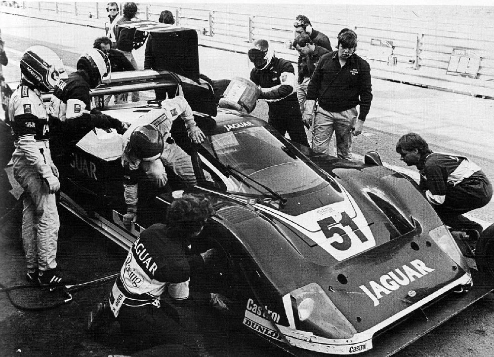Brundle in the XJR-6 pit lane surrounded by mechanics