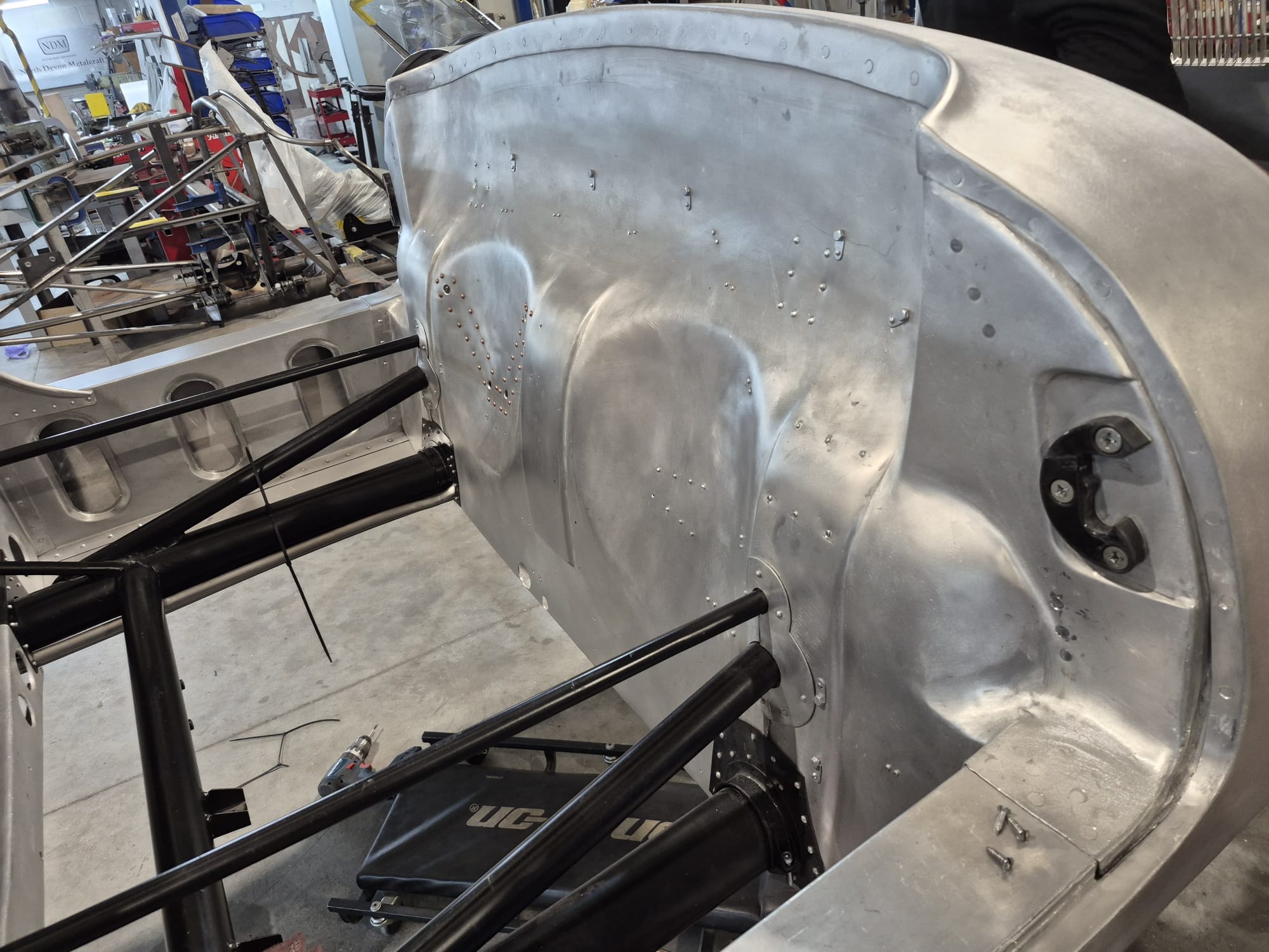Hand-formed aluminium panel over the tubular frame